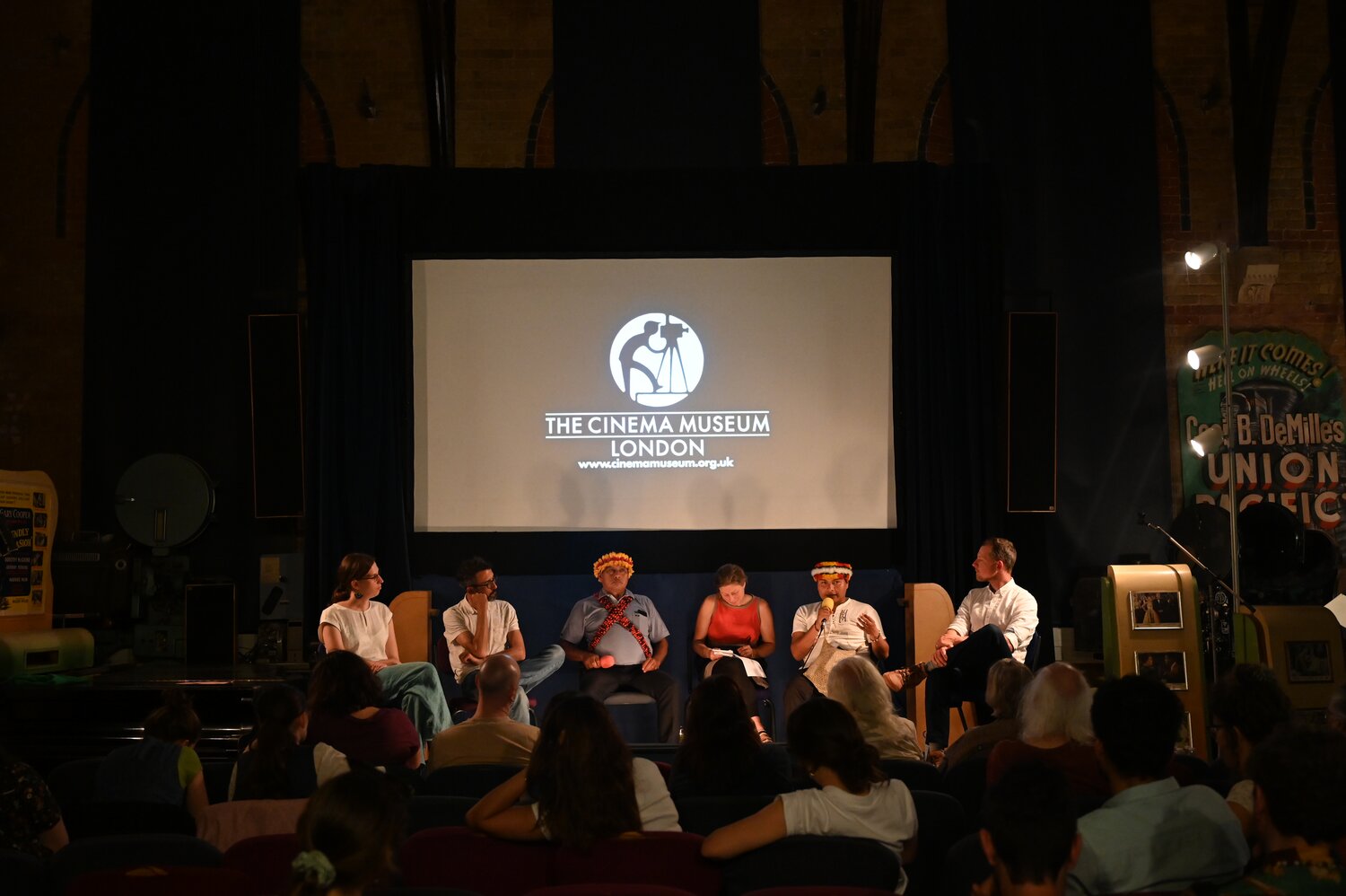 A panel and a group of people watching a film