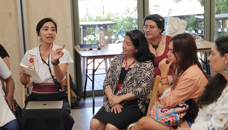 A women speaking whilst people listen.