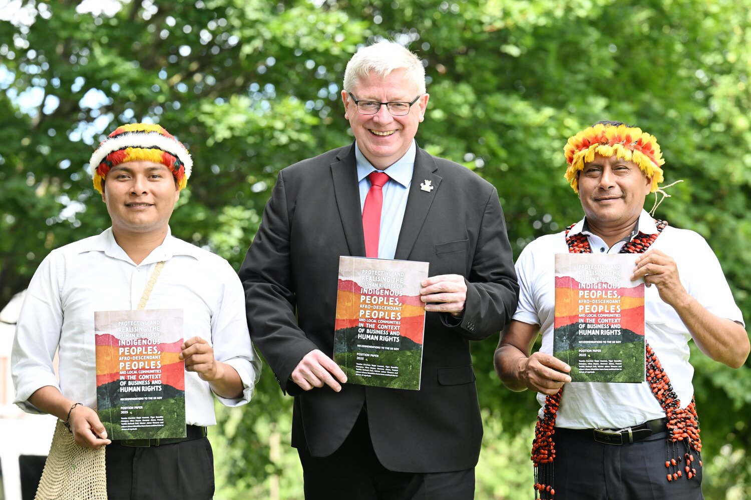 Three people stood with a report in their hand.