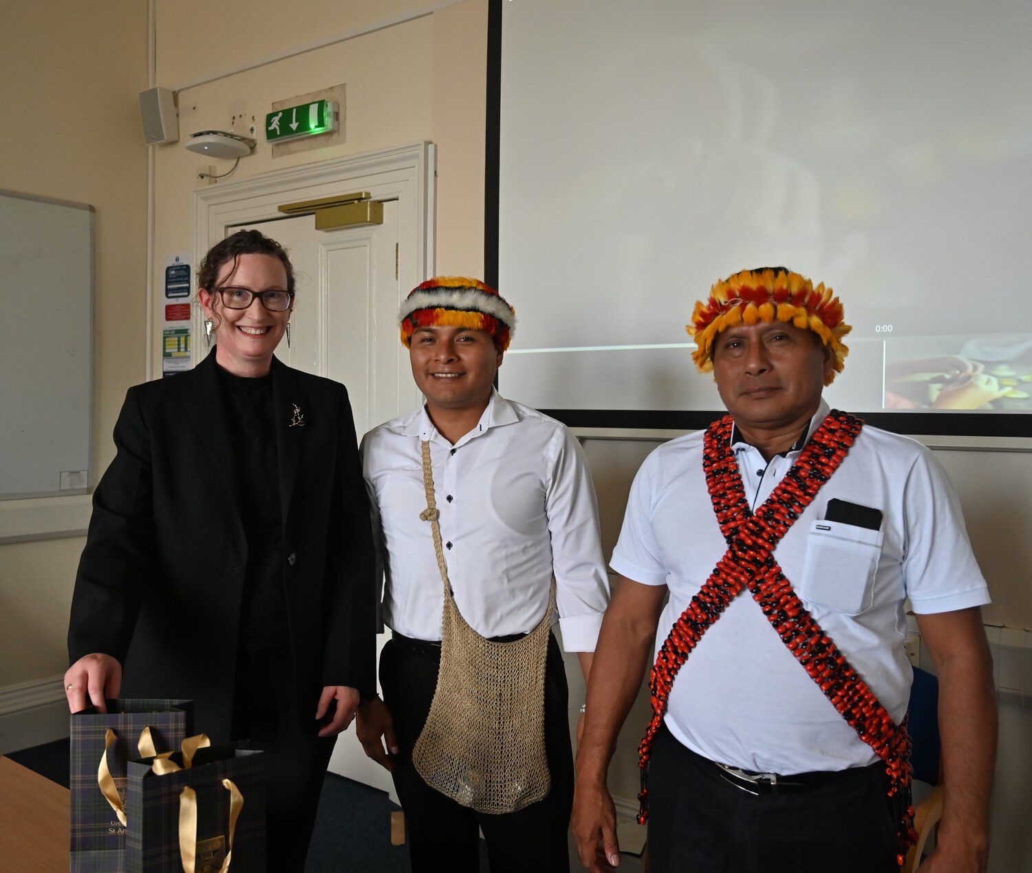 A women and two men stood together smiling