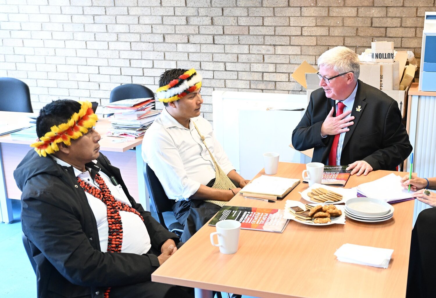 Three men talking around a table