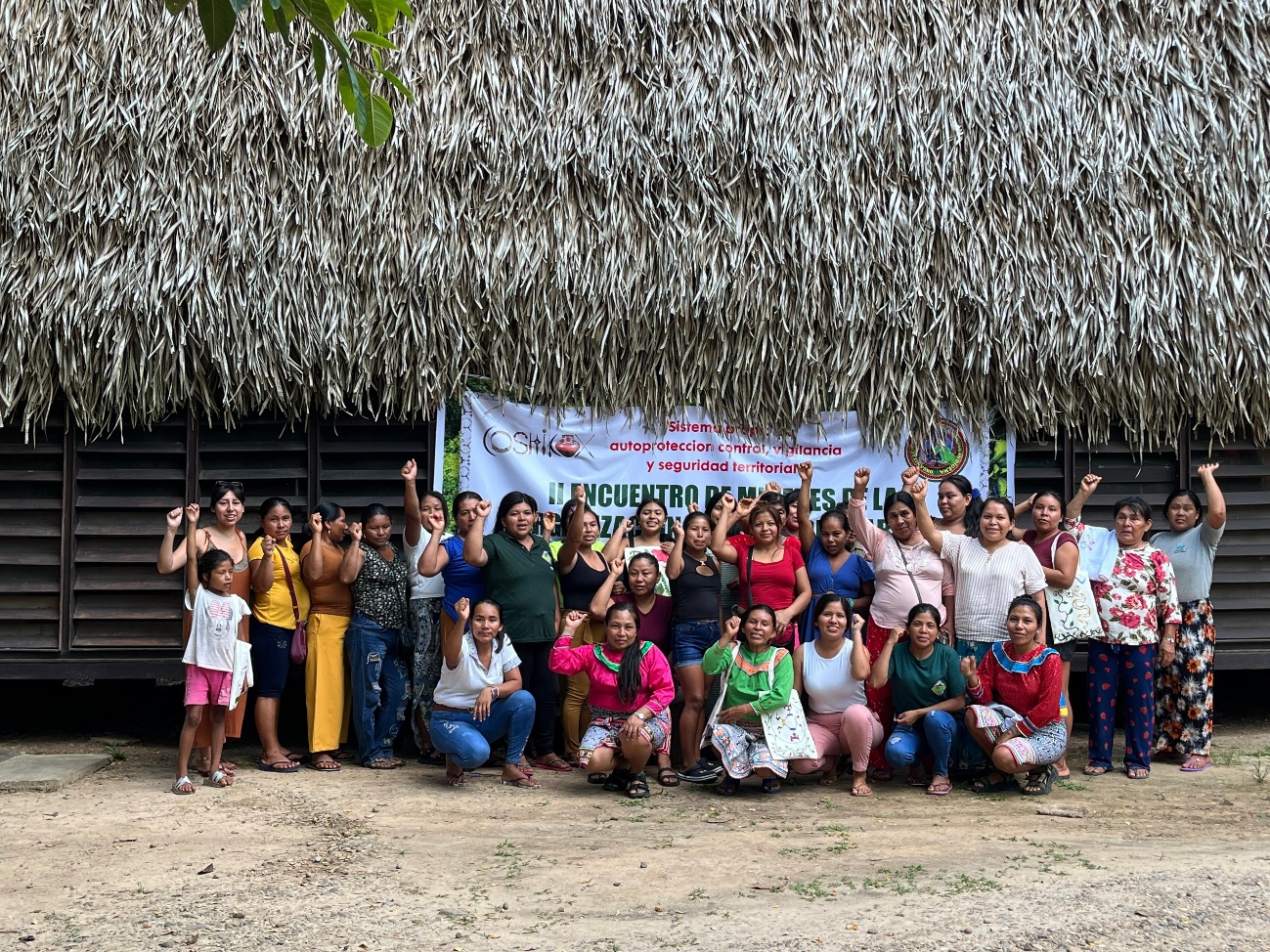 Un grupo de mujeres estaba de pie delante de una pancarta